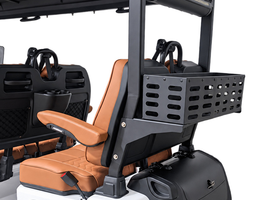 Open-air utility vehicle cockpit featuring orange-brown seats, a rear metal storage basket, and a compact, modular passenger area intended for work tasks in a rugged environment.